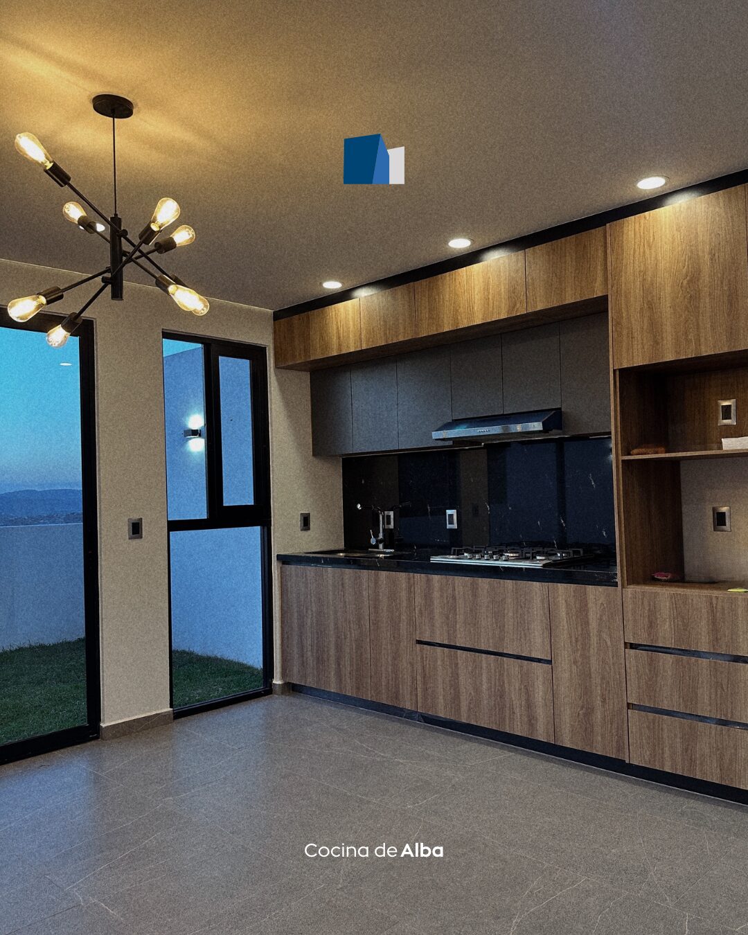 Cocina integral de Casa Alba con cubierta negra y carpintería en madera · Mircon Constructora en Morelia