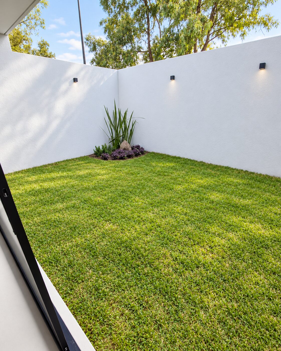 Jardín trasero con pasto natural y muros blancos · Casa Magna, Mircon Constructora en Morelia
