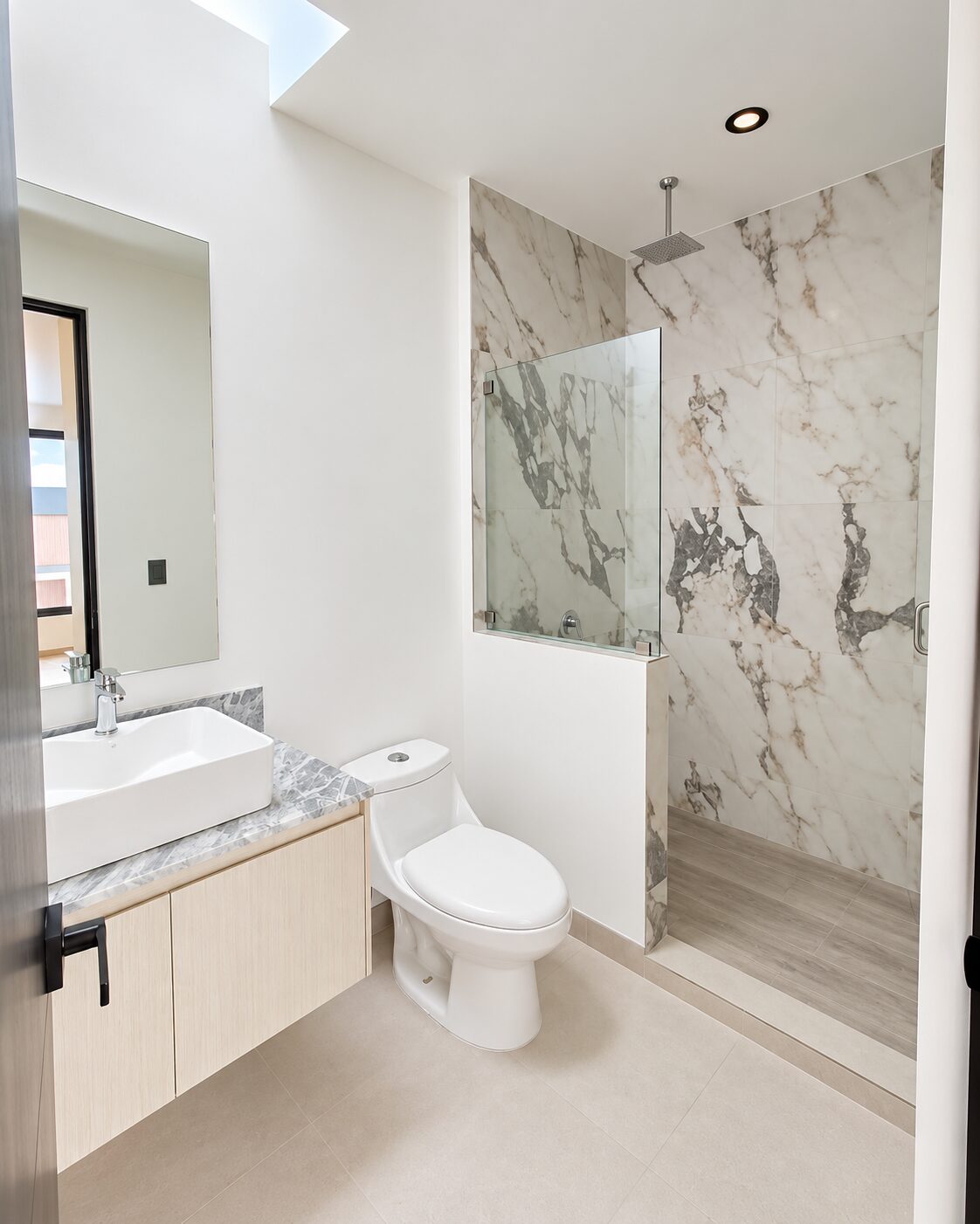 Baño completo con regadera de mármol y cancel de cristal · Casa Magna, Mircon Constructora