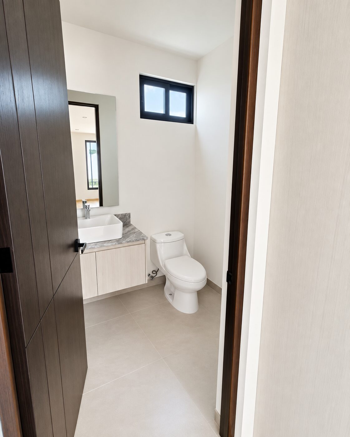 Medio baño de visitas con puerta de madera · Casa Magna, Mircon Constructora