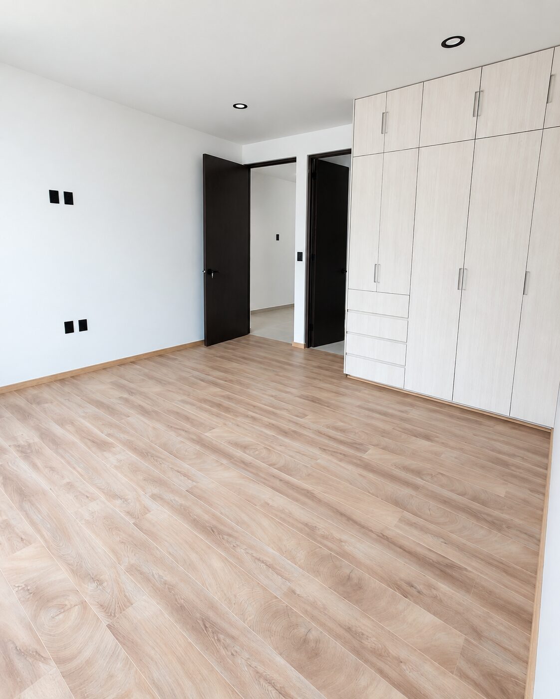 Recámara principal con clóset de madera y piso tipo madera · Casa Magna, constructora en Morelia