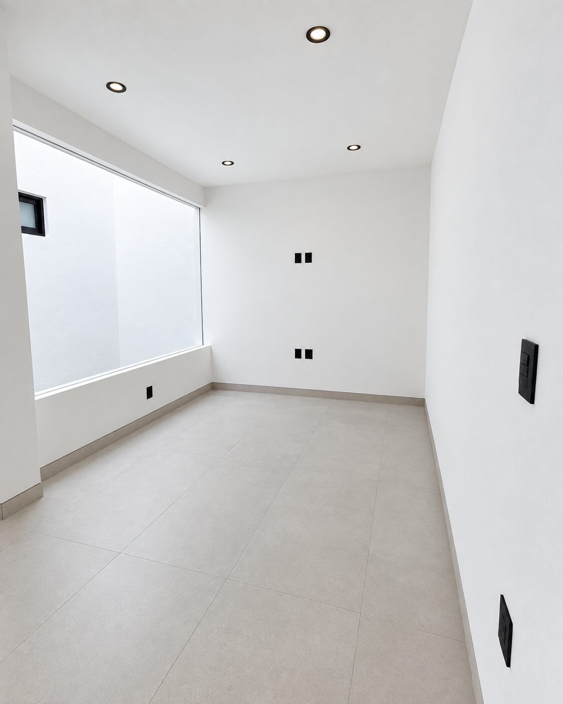 Estudio con ventanal al patio de luz · Casa Magna por Mircon Constructora en Morelia