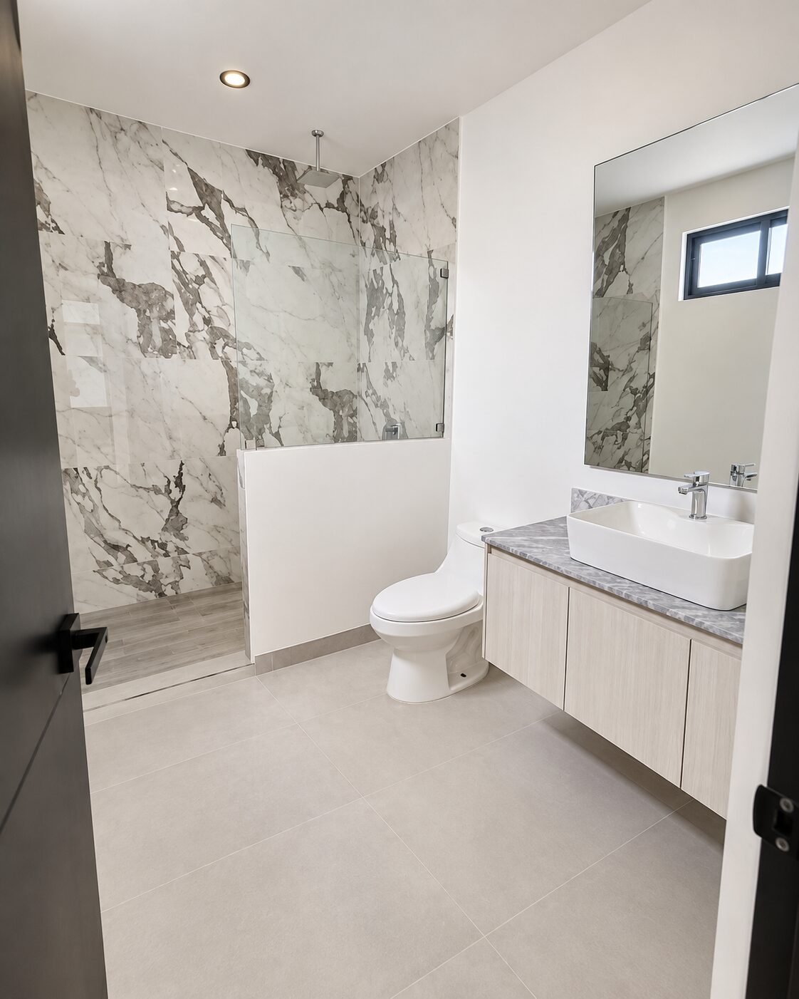 Baño principal con muros de mármol y regadera · Casa Magna, Mircon Constructora